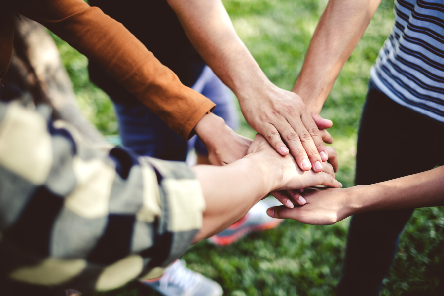 People placing hands on top of one another